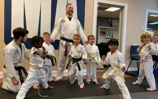 a person teaching children in karate uniforms