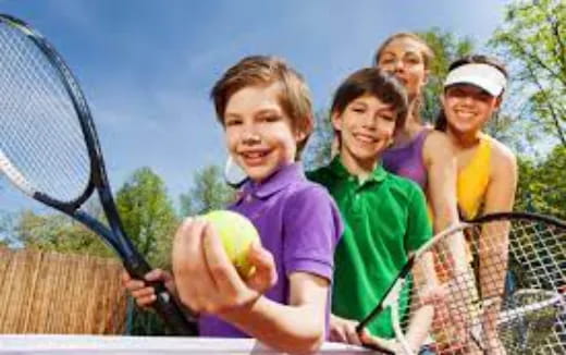 a group of girls holding tennis rackets and a ball
