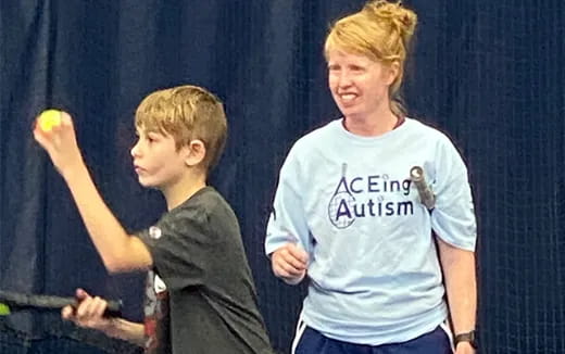 a person and a boy playing tennis