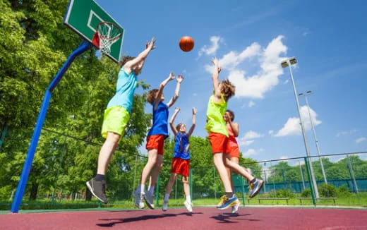 a group of people playing basketball