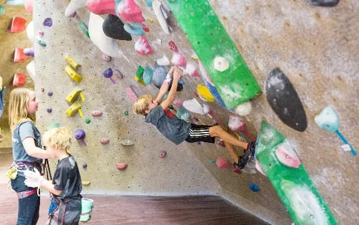 a group of kids playing on a rock wall