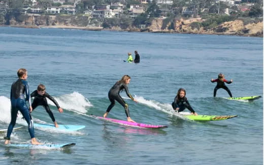 a group of people surfing in the sea