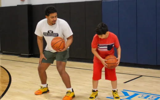 a person and a boy playing basketball