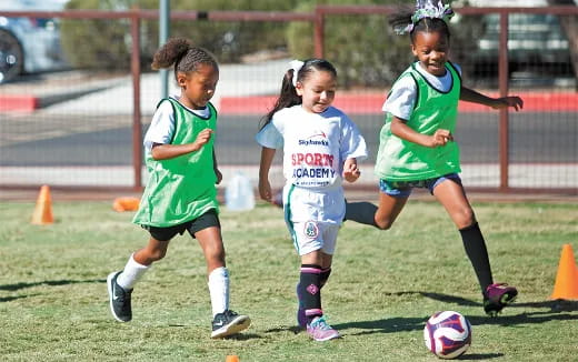 a group of girls compete over a football ball