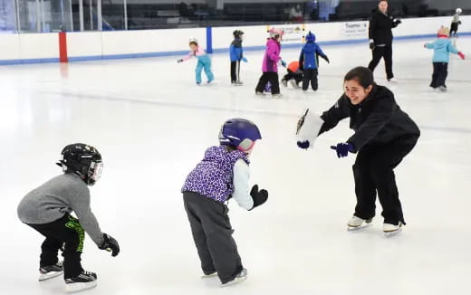 a person and a couple of kids on ice skates