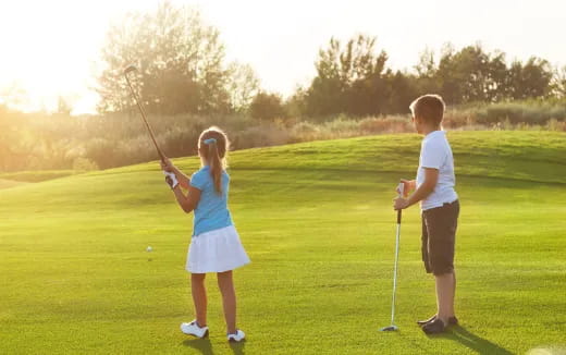 a person and a boy playing golf