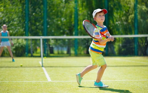 a kid playing tennis