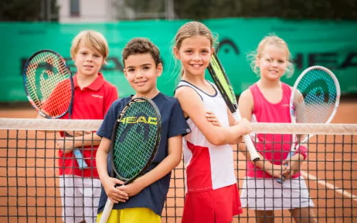 a group of kids holding tennis rackets