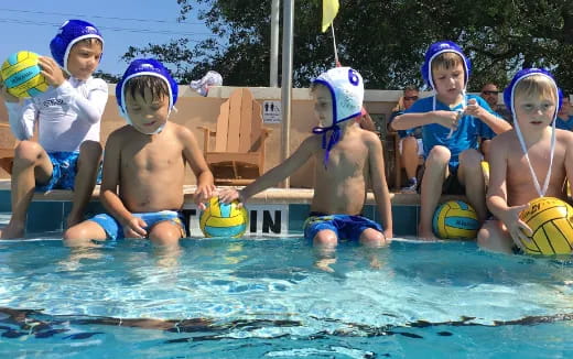 a group of kids playing in a pool