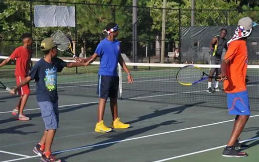 a group of people playing tennis