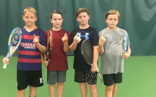 a group of boys holding tennis rackets