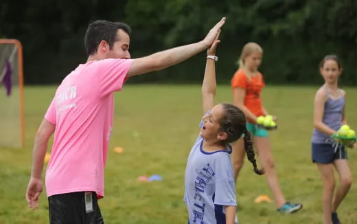 a person and a group of children playing football