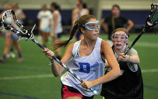 a couple of women playing lacrosse