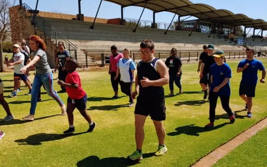 a group of people running on a grass field