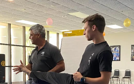 a person sitting on a chair talking to another man