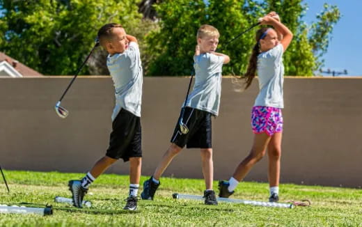 a group of kids playing golf