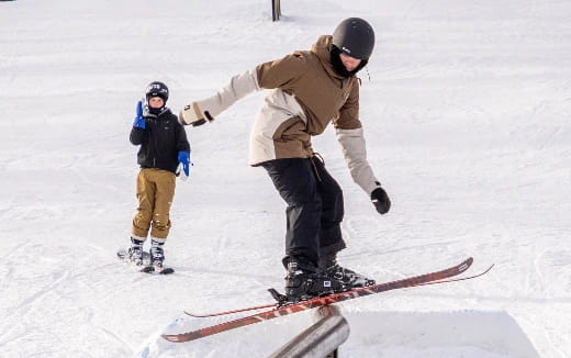 a couple of people stand on snow skis