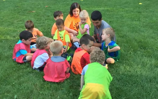a group of children sitting on the grass