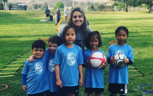 a group of children holding football balls