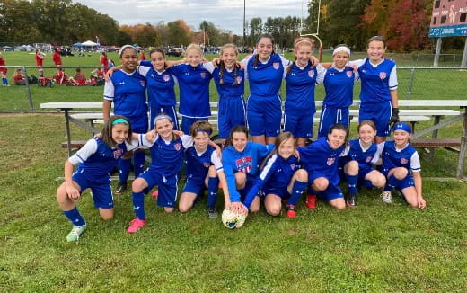 a group of girls in blue uniforms posing for a photo