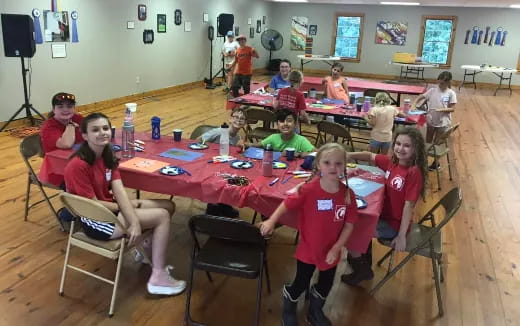a group of children sitting at a table in a classroom