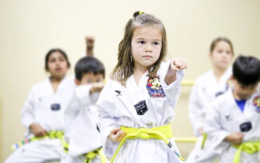 a group of children in white uniforms