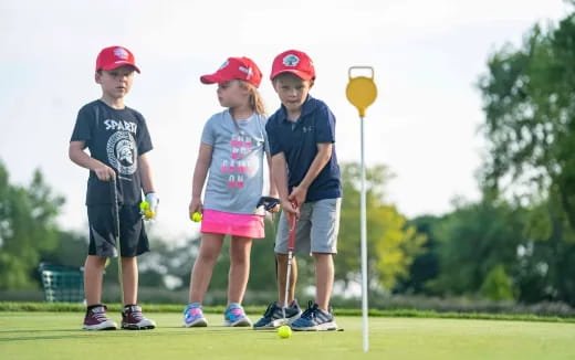 a group of kids playing golf