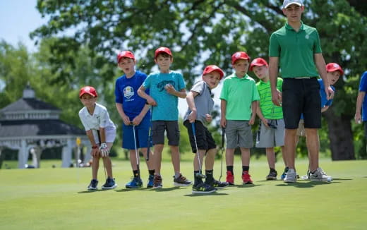 a group of people standing on a golf course