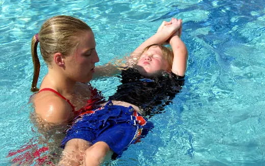 a person and a girl in a pool