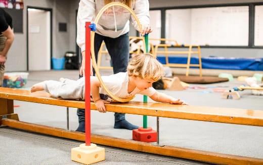 a child playing on a wooden structure