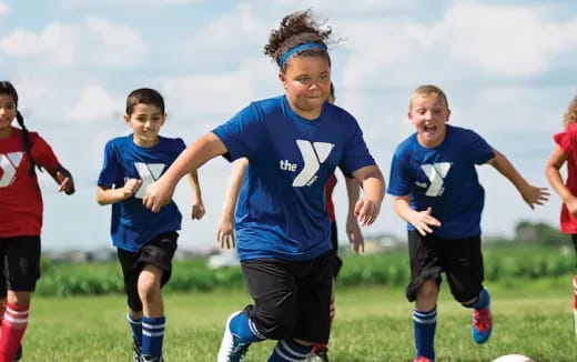 a group of kids running on a field