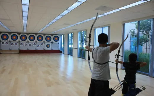 a person and a boy shooting bows