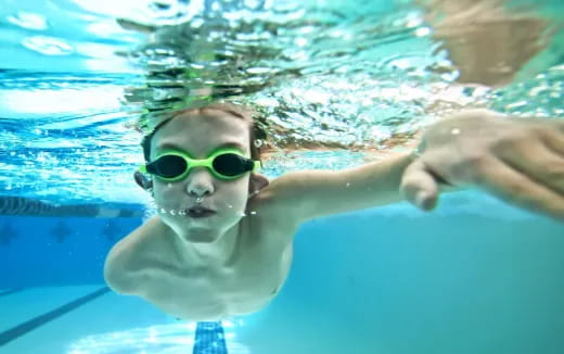 a person wearing goggles and swimming