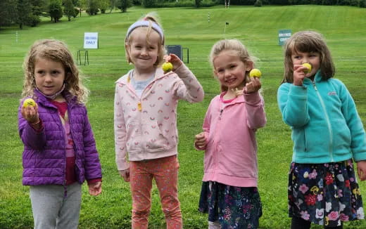 a group of girls holding fruit