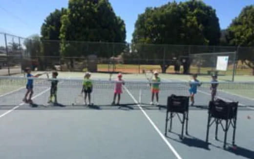 a group of kids playing tennis