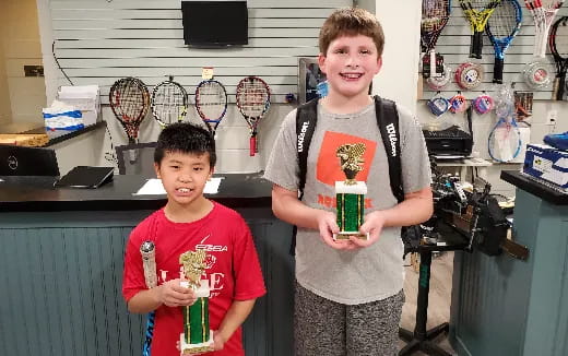 two boys holding trophies