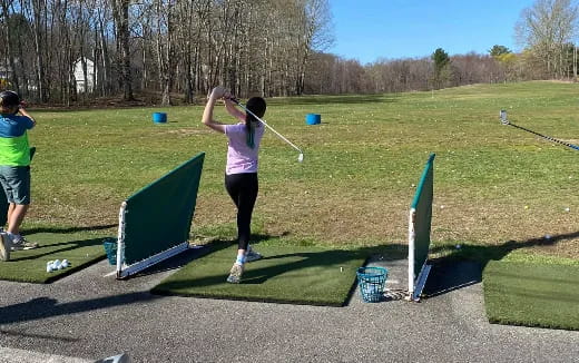 a person swinging a golf club