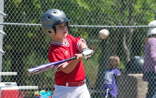 a young boy swinging a baseball bat