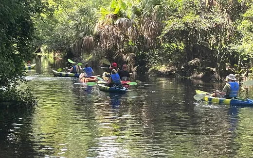 a group of people in canoes on a river