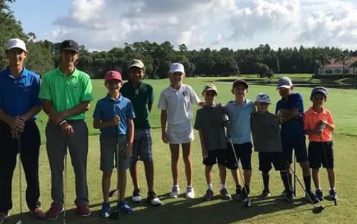 a group of people standing on a golf course