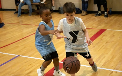 a couple of young boys playing basketball