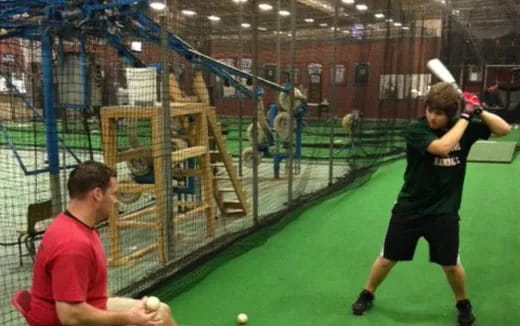 a person hitting a ball with a baseball bat