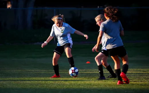 girls playing football on a field