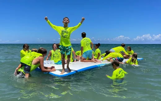 a group of people on a surfboard in the water