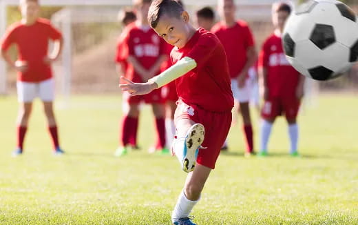 a boy kicking a football ball