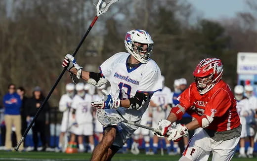 a couple of men playing lacrosse