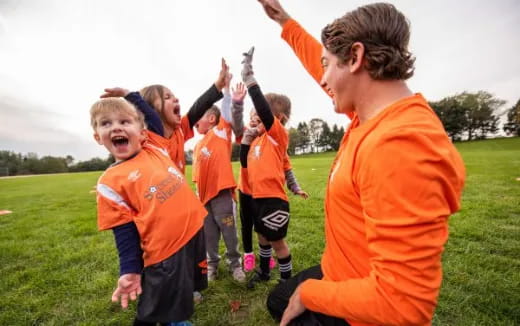 a group of kids in orange uniforms