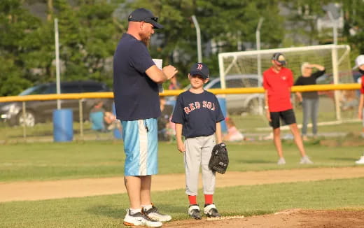 a person and a boy playing baseball