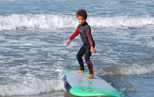 a boy on a surfboard in the ocean