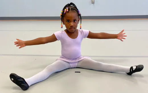 a girl in a white outfit on a white surface